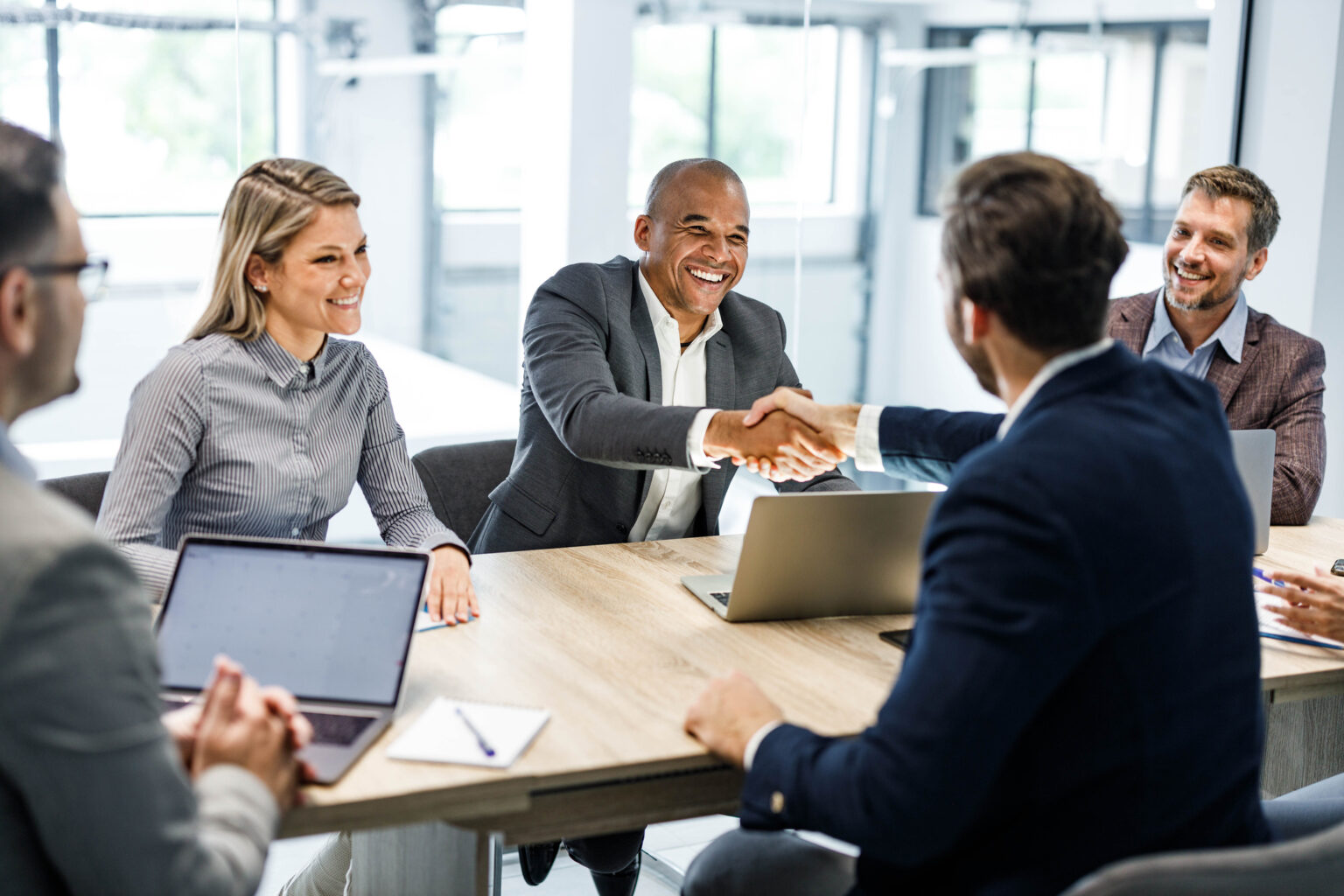 Happy businessmen shaking hands on a meeting in the office