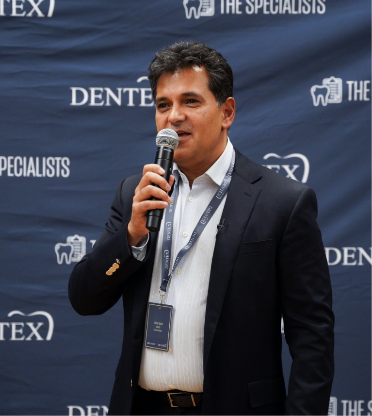 Rahul with microphone at a speaking engagement for Dentex